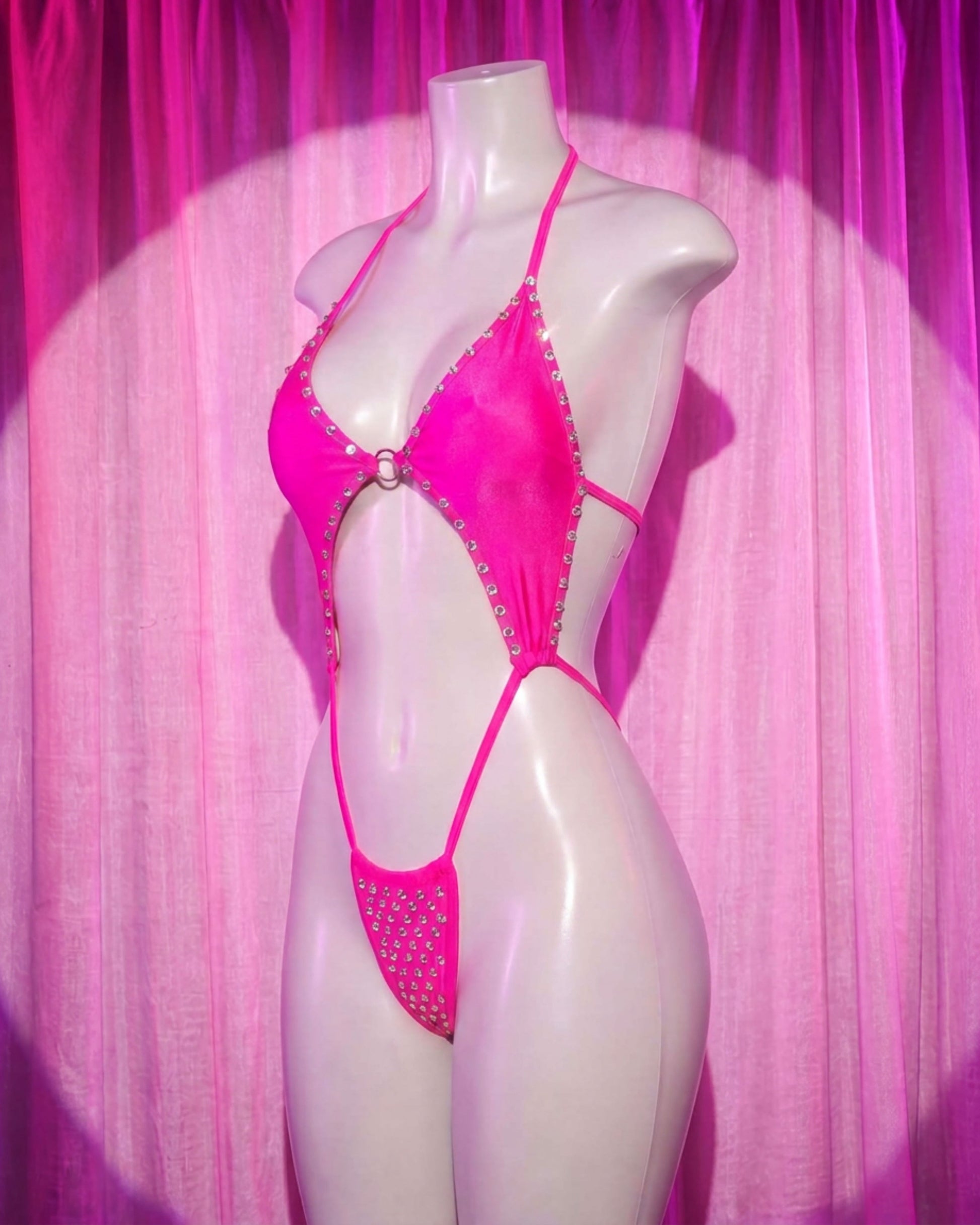 Side view of Doll pink rhinestone slingshot stripper bodysuit with ring detail and thong cut